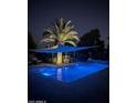 Night view of a modern pool and landscape illuminated under a shade, creating a serene outdoor retreat at 6323 E Gold Dust Ave, Paradise Valley, AZ 85253