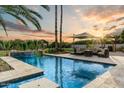 Stunning pool with a waterfall feature, lounge area, and lush landscaping at sunset, perfect for outdoor entertaining at 6323 E Gold Dust Ave, Paradise Valley, AZ 85253