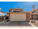 Tan two-story home with a two car garage featuring brick trim on either side under a bright sunny sky at 6405 W Saguaro Dr, Glendale, AZ 85304