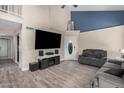 Bright and airy living room with a large television, staircase, and wood floors at 6405 W Saguaro Dr, Glendale, AZ 85304