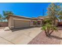 Tan single-story home with a desert-landscaped front yard, concrete driveway and a two-car garage at 6640 W Honeysuckle Dr, Phoenix, AZ 85083