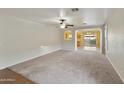 Spacious carpeted living room featuring a ceiling fan and arched doorway to dining at 8434 E Natal Cir, Mesa, AZ 85209