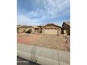 Attractive single-level home with a spacious driveway, decorative rock landscaping, and a two-car garage with stone accents at 8536 W Rockwood Dr, Peoria, AZ 85382