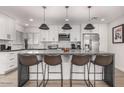Bright, modern kitchen featuring a large island, stainless appliances, and stylish pendant lighting at 8602 E Mitchell Dr, Scottsdale, AZ 85251