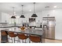 Modern kitchen with stainless steel appliances, white cabinets, and a large center island at 8602 E Mitchell Dr, Scottsdale, AZ 85251