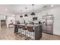 Open-concept kitchen with white cabinets, a large island, stainless steel appliances and eat-in bar at 8602 E Mitchell Dr, Scottsdale, AZ 85251