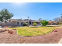 Well-maintained home showcasing a manicured lawn, mature trees, and beautiful desert landscaping at 8621 W Via Montoya Dr, Peoria, AZ 85383