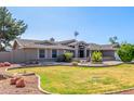 Charming home with a neat front yard, mature trees, and attractive desert landscaping at 8621 W Via Montoya Dr, Peoria, AZ 85383