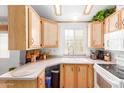 Bright kitchen with wooden cabinets, white appliances, and a view from the window at 8700 E University Dr # 2674, Mesa, AZ 85207