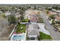 An aerial view of a home with a pool, trampoline, green grass, and a large driveway at 9505 S Kenneth Pl, Tempe, AZ 85284