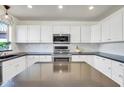 Modern kitchen features white cabinetry, subway tile backsplash, stainless steel appliances, and a dark countertop at 9652 E Ludlow Dr, Scottsdale, AZ 85260