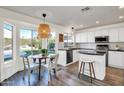 Bright kitchen with stainless steel appliances, white cabinets, and a breakfast nook with backyard views at 9652 E Ludlow Dr, Scottsdale, AZ 85260