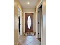 Home foyer with a decorative oval front door and tiled floors at 10323 W Carousel Dr, Arizona City, AZ 85123