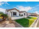 Beautiful single-story home with desert landscaping, lush green lawn, and a cozy front patio at 11307 E Ellis St, Mesa, AZ 85207