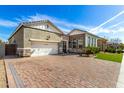 Lovely home exterior with a brick driveway and a well-maintained lawn under a clear blue sky at 1143 N Quinn --, Mesa, AZ 85205