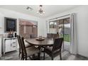 Cozy dining room featuring a rustic table and chairs, a sliding glass door, and backyard views at 11843 W Cambridge Ave, Avondale, AZ 85392