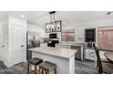 Bright kitchen featuring stainless steel appliances, an island with seating, and a stylish pendant light fixture at 11843 W Cambridge Ave, Avondale, AZ 85392