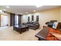 Bright living room featuring a comfortable couch, large coffee table, piano, and neutral carpet at 13404 W Copperstone Dr, Sun City West, AZ 85375