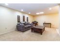 Comfortable living room with a cozy couch, coffee table, neutral carpet, and stylish wall decor at 13404 W Copperstone Dr, Sun City West, AZ 85375