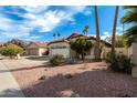 Charming single-story home featuring a two-car garage, desert landscaping, and mature palm trees at 15431 S 36Th Pl, Phoenix, AZ 85044