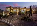 Front of home with desert landscaping, including cacti and succulents, at dusk at 15501 E Tepee Dr, Fountain Hills, AZ 85268