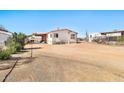 Exterior mobile home on dirt lot featuring covered parking and fenced yard at 1936 S Mariposa Rd, Apache Junction, AZ 85119