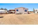 Exterior view of a mobile home with covered parking, chairs, and a dirt lot at 1936 S Mariposa Rd, Apache Junction, AZ 85119