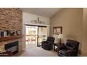 Inviting living room featuring a cozy fireplace, plush seating, and sliding glass doors leading to a private balcony at 205 N 74Th St # 234, Mesa, AZ 85207