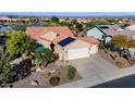 Aerial view of a desert home featuring a three car garage, solar panels, tile roof, and manicured landscaping at 21500 N 262Nd Ln, Buckeye, AZ 85396