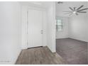 Bright room with tile and carpet flooring, a ceiling fan, a window, and a white door and trim at 22679 E Estrella Rd, Queen Creek, AZ 85142