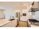 Bright kitchen boasts stainless steel appliances, a large island, and ample white cabinetry at 25180 N 177Th Dr, Surprise, AZ 85387