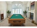 Bright game room features a billiard table, fireplace, large window, light colored walls and flooring at 3145 W Sandra Ter, Phoenix, AZ 85053