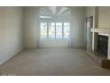 Bright living room features a fireplace, large window, light colored walls and flooring at 3145 W Sandra Ter, Phoenix, AZ 85053