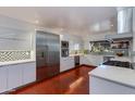 Well lit kitchen featuring sleek white cabinets, stainless steel appliances, mosaic backsplash, and terracotta floors at 3237 E Meadowbrook Ave, Phoenix, AZ 85018