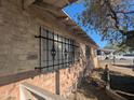 Side view showcasing brick facade and barred windows under clear blue skies at 3932 W Bethany Home Rd, Phoenix, AZ 85019