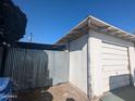 Garage with peeling paint and a corrugated metal fence against a blue sky at 3932 W Bethany Home Rd, Phoenix, AZ 85019