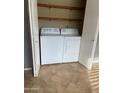 Laundry closet with a white washer and dryer and shelving at 4107 E Charter Oak N Rd, Phoenix, AZ 85032