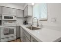 Cozy kitchen features gray cabinets, white appliances, and a stainless steel sink at 4630 N 68Th St # 213, Scottsdale, AZ 85251