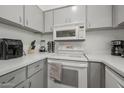 Cozy kitchen features gray cabinets, white appliances, and modern countertop appliances at 4630 N 68Th St # 213, Scottsdale, AZ 85251