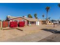 View of the home with a simple front yard, palm trees, and desert landscaping at 5952 W Coronado Rd, Phoenix, AZ 85035