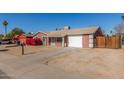 Suburban house features a simple front yard, garage, and low-maintenance desert landscaping at 5952 W Coronado Rd, Phoenix, AZ 85035