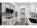 Bright kitchen features white cabinetry, modern appliances, a black faucet, and a laundry area at 628 Leisure World --, Mesa, AZ 85206