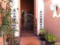 View through the ornate front gate, showcasing a welcoming entrance to the home, surrounded by lush greenery at , Gilbert, AZ 85234