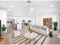 Bright, open living room with white tile floors and modern furnishings flowing into the kitchen at 10064 E Tamery Ave, Mesa, AZ 85212