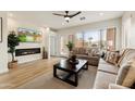 Cozy living room with a fireplace, comfortable sofas, a ceiling fan, and natural light streaming through the windows at 11500 E Cochise Dr # 1090, Scottsdale, AZ 85259