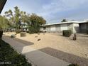 Well-maintained front yard with desert landscaping, mature trees, and a view of the home's facade at 13808 N 108Th Dr, Sun City, AZ 85351