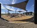 Inviting playground with modern shade structures and diverse play equipment on a wood chip surface at 15652 W Deanne Dr, Waddell, AZ 85355