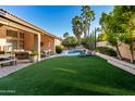 Expansive backyard featuring lush artificial turf, a refreshing pool, and ample lounging space at 16428 N 59Th St, Scottsdale, AZ 85254