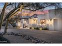 Home exterior featuring desert landscaping, and a striking architectural design, complemented by a beautiful Arizona sunset at 22619 N La Senda Dr, Scottsdale, AZ 85255