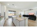 Open-concept kitchen with a granite island, white cabinetry, stainless steel appliances, and sliding door at 22924 E Desert Spoon Dr, Queen Creek, AZ 85142